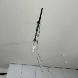 חוטי חשמל תלויים מהתקרה ליד סולם