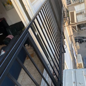 מעקה מתכת מותקן על מרפסת בניין