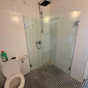 מקלחון זכוכית עם ראש מקלחת ותא שירותים