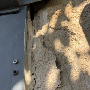 קיר עם סדקים ותפרים ליד מתכת