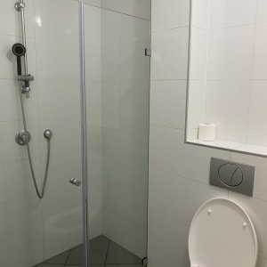 מקלחון ושירותים עם קירות אריחים לבנים