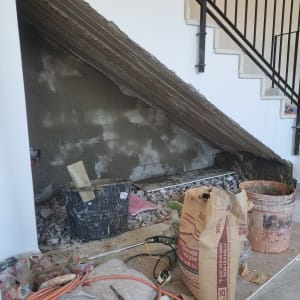 שק מלט, דלי, כבלים וכלי עבודה בשיפוץ מתחת למדרגות