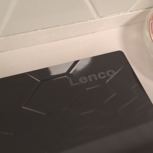 מכשיר שחור עם דוגמת משושים ולוגו "Lenco"