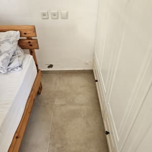 קיר עם סימני רטיבות ליד מיטה וארון