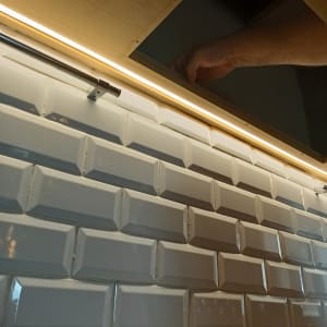 יד מתקינה תאורת לד מתחת לארון מטבח