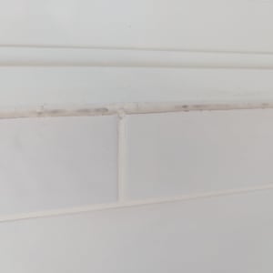 אריחי קרמיקה לבנים עם רובה מתקלפת