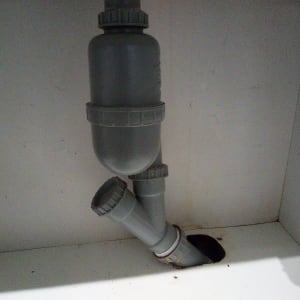 צנרת פלסטיק מתחת לכיור עם מחבר T