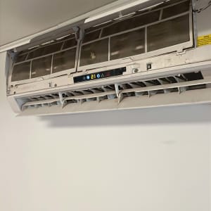 מזגן מותקן על קיר עם מכסה פתוח