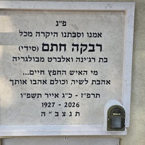 מצבה עם כיתוב בעברית על קיר