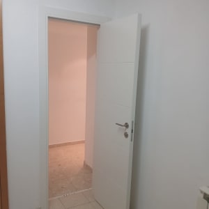 דלת לבנה פתוחה בחדר עם קירות לבנים