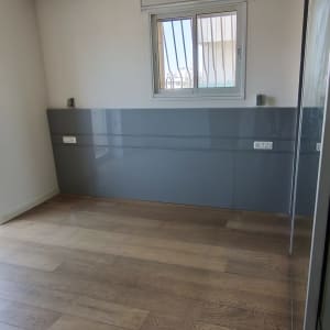 חדר עם רצפת עץ וקיר צבוע אפור