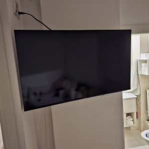 טלוויזיה מותקנת על קיר עם כבל חשמל מחובר