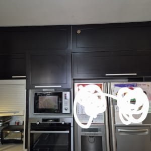 מטבח עם ארונות כהים ומכשירי חשמל מודרניים