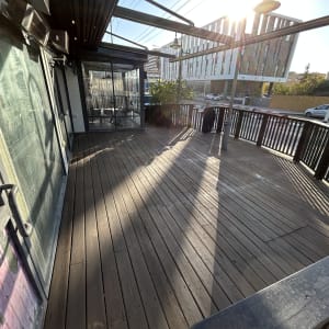 מרפסת עץ עם מעקה וגג זכוכית