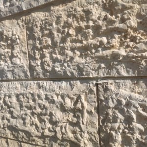 קיר אבן מחוספס עם חריצים אופקיים ואנכיים