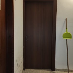 דלת עץ חומה עם ידית מתכת כסופה