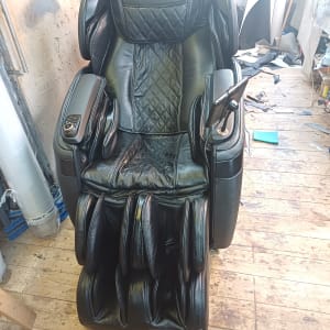 כיסא עיסוי שחור בסדנה עם רצפת עץ