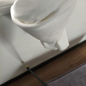 ריסוס קיר עם צינור התזה ליד וילון לבן