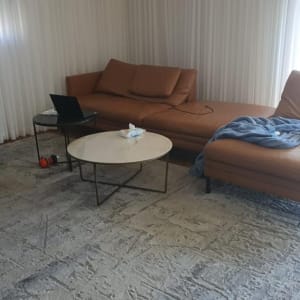 ספה עם שמיכה, שולחן עם מחשב נייד ומשקולת