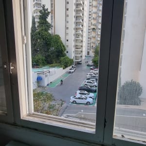חלון זכוכית עם נוף של בניינים וחניה