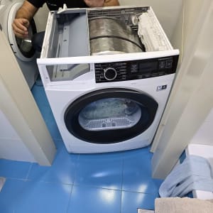 תיקון מכונת כביסה עם טכנאי בחדר כביסה