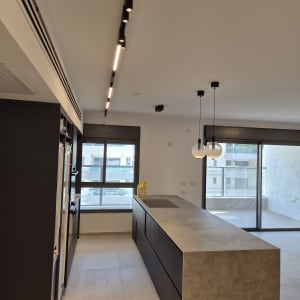 התקנת גופי תאורה מעוצבים ופס צבירה במטבח מודרני