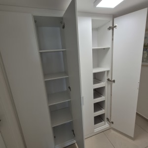 ארון לבן עם דלתות פתוחות ומדפים פנימיים