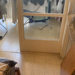 דלת זכוכית עם בגדים תלויים מאחוריה