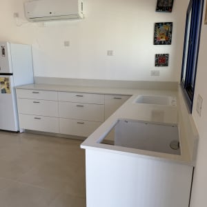 מטבח עם משטחי שיש לבנים וארונות לבנים