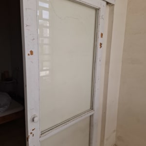 דלת זכוכית עם מסגרת עץ מתקלפת