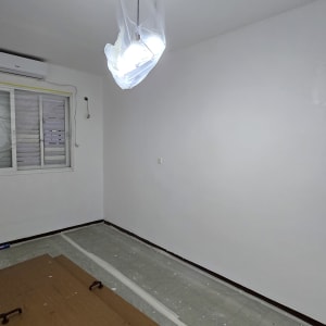 חדר צבוע בלבן עם מכסה צבע על הרצפה