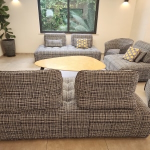 ספות מרופדות בבד משובץ עם כריות דקורטיביות