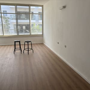 רצפת פרקט עץ בהירה בחדר ריק עם שני כיסאות