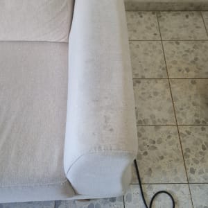 ספה בהירה על רצפת אריחים עם כבל חשמלי