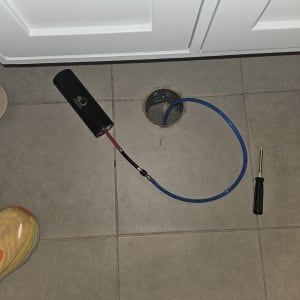 צינור כחול וכלי עבודה על רצפה אפורה