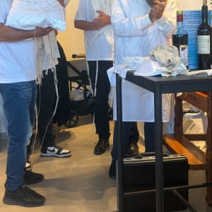 טקס ברית מילה עם אנשים ובקבוקי יין