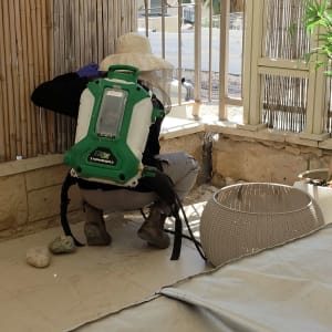 אדם עם ציוד הדברה במרפסת