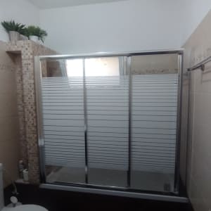 מקלחון עם דלתות זכוכית ותא שירותים