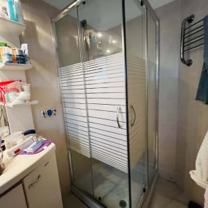 מקלחון זכוכית עם דלתות הזזה וידיות מתכת