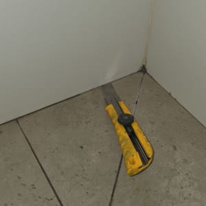 סכין חיתוך על רצפה ליד קיר