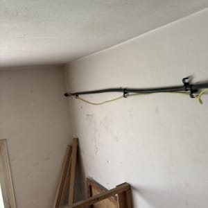 צינור שחור מחובר לקיר עם חוטים צהובים