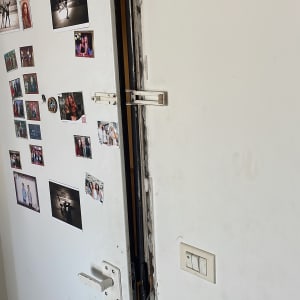 דלת לבנה עם מנעול שבור ותמונות קטנות