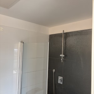 חדר אמבטיה עם מקלחון וקירות אריחים
