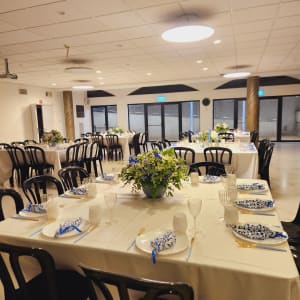 שולחנות ערוכים עם מפות לבנות וסידורי פרחים