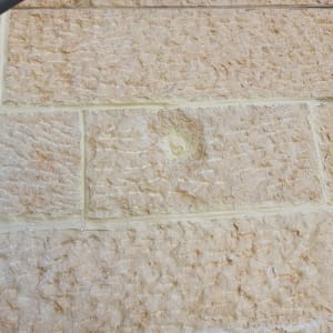 עבודת חיזוק ואיטום אריחי אבן בחזית בניין בגובה