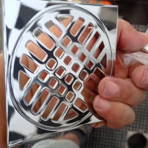 יד מחזיקה רשת ניקוז מתכתית מבריקה