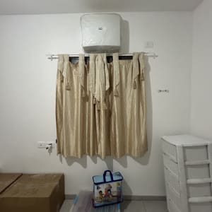 חדר עם וילון, מזגן וארגזים על הרצפה