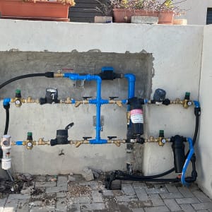 צנרת מים עם ברזים ומחברים כחולים ושחורים