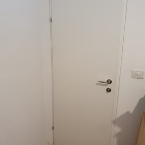 דלת לבנה עם ידית מתכת בחדר פנימי