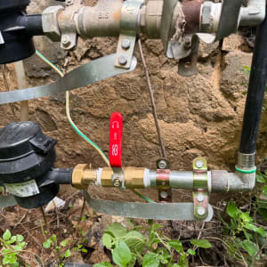 צנרת ומחברים עם שסתום אדום בגינה